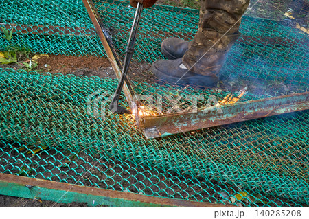 Gas cutting.Worker cuts metal construction waste with a chop saw 140285208