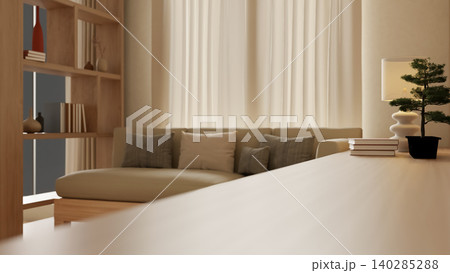 Side view of wooden table with books, bonsai pot and lamp beside sofa across shelf in a living room. Side view of wooden table with books, bonsai pot and lamp beside sofa across shelf in a living room. 140285288