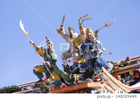 Chinese Guardian Deities on Temple Roof Against Blue Sky Chinese Guardian Deities on Temple Roof Against Blue Sky 140285449