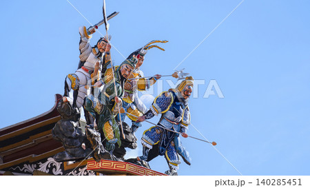 Chinese Guardian Deities on Temple Roof Against Blue Sky Chinese Guardian Deities on Temple Roof Against Blue Sky 140285451
