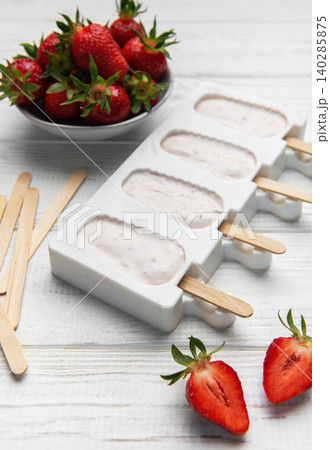 Making strawberry frozen yogurt popsicles for a healthy summer dessert Making strawberry frozen yogurt popsicles for a healthy summer dessert 140285875
