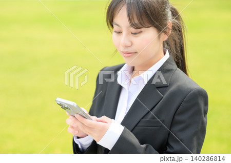 スマートフォンを操作する20代日本人女性会社員 スマートフォンを操作する20代日本人女性会社員 140286814