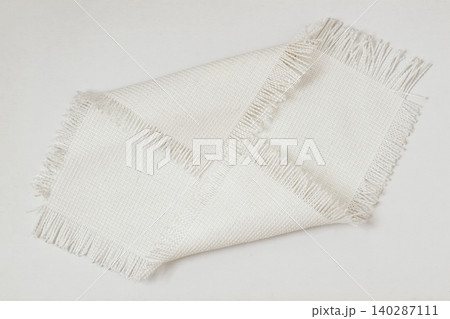 Fabric texture sample with woven threads and fringe edges placed on surface, textile sample, neutral modern tone, detailed weave pattern for design. Natural background, fabric texture 140287111