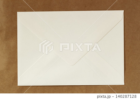 Envelope on kraft paper background with closed flap, fold lines, copy space for mailing layout, branding, office design. Concept of envelope, correspondence, letter, invitation, postal service Envelope on kraft paper background with closed flap, fold lines, copy space for mailing layout, branding, office design. Concept of envelope, correspondence, letter, invitation, postal service 140287128