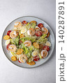Caesar salad with tiger prawns, cherry tomatoes, croutons, parmesan cheese, quail eggs and romaine lettuce. Traditional American dish. Close-up, selective focus. 140287891