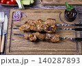 Traditional Russian shashlik on skewers with vegetables. Grilled pork meat (shish kebab). Close-up. 140287893