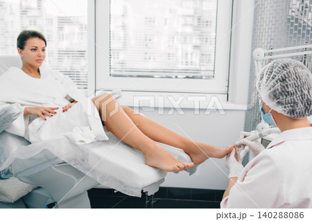 procedure of hardware manicure on women's legs. Chiropodist care about clients foot. 140288086