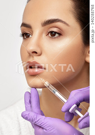 Sensual female lips, procedure lip augmentation. Syringe near woman's mouth, injections for increase lips shape, high quality 140288768