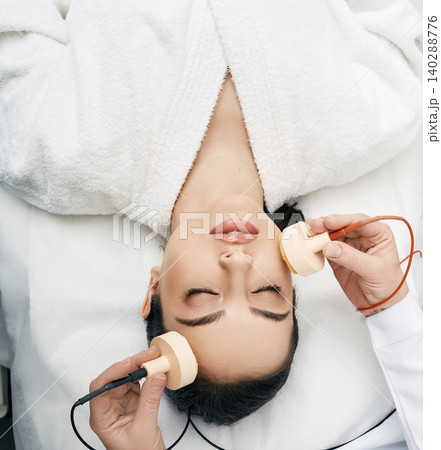 Beautiful woman receives microcurrent procedure for a facelift. Skin rejuvenation and face lift with microcurrent therapy Beautiful woman receives microcurrent procedure for a facelift. Skin rejuvenation and face lift with microcurrent therapy 140288776