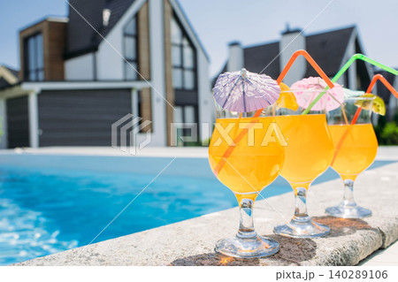 glass of fresh orange juice by the poolside. Summer cocktail 140289106