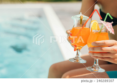glass of fresh orange juice by the poolside. Summer cocktail glass of fresh orange juice by the poolside. Summer cocktail 140289107