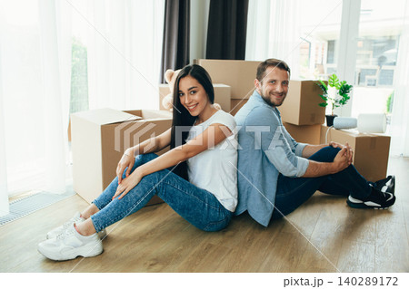 moving new house. Young happy couple unpacking cardboard boxes into their new apartment 140289172