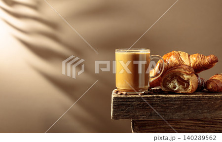 Coffee latte with croissants on an old wooden table. Coffee latte with croissants on an old wooden table. 140289562
