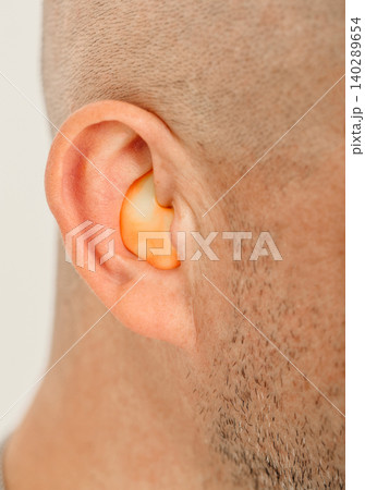 Customized orange ear plugs for noisy places. Personally molded earplugs for human ear. 140289654