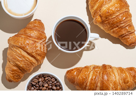 Cups of cappuccino and espresso, coffee beans and croissants on a yellow isolated background Cups of cappuccino and espresso, coffee beans and croissants on a yellow isolated background 140289714