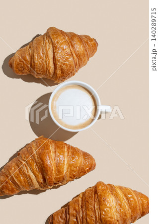 Cup of cappuccino coffee and croissants on a yellow isolated background 140289715