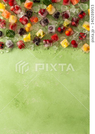 Green background with ice cubes with frozen berries and fruits and mint Green background with ice cubes with frozen berries and fruits and mint 140289953