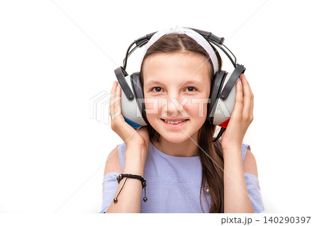 Hearing test. Positive girl in headphones during a hearing test, isolated on white. Audiometry 140290397