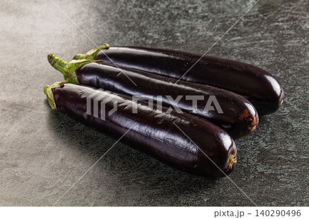 Three fresh purple eggplants on dark stone background Three fresh purple eggplants on dark stone background 140290496