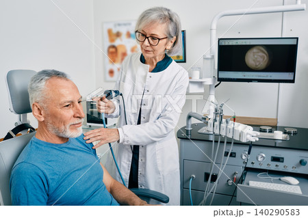 Ear endoscopy. ENT doctor examining mature man's ear using endoscope at otolaryngology clinic Ear endoscopy. ENT doctor examining mature man's ear using endoscope at otolaryngology clinic 140290583
