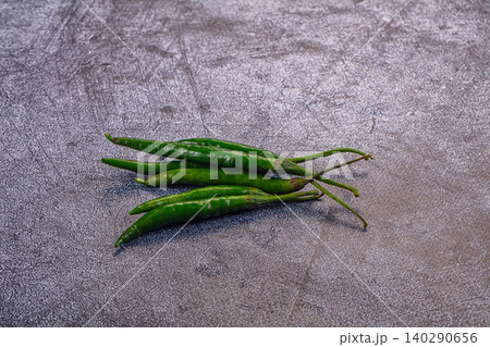Fresh green chili peppers on gray stone surface 140290656