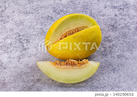 Yellow melon with slice on gray stone background Yellow melon with slice on gray stone background 140290658