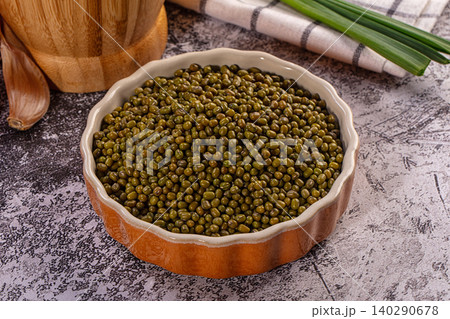 Green mung beans in ceramic bowl, fresh garlic clove, green onions, rustic kitchen setting Green mung beans in ceramic bowl, fresh garlic clove, green onions, rustic kitchen setting 140290678