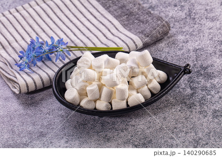 White marshmallows in black leaf shaped bowl with blue flowers White marshmallows in black leaf shaped bowl with blue flowers 140290685