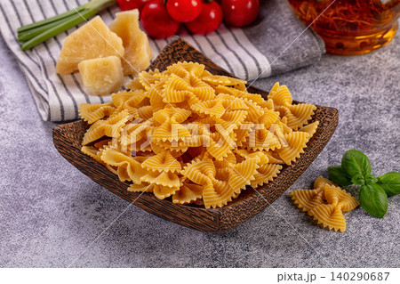 Uncooked Farfalle Pasta in Wooden Bowl with Ingredients Uncooked Farfalle Pasta in Wooden Bowl with Ingredients 140290687