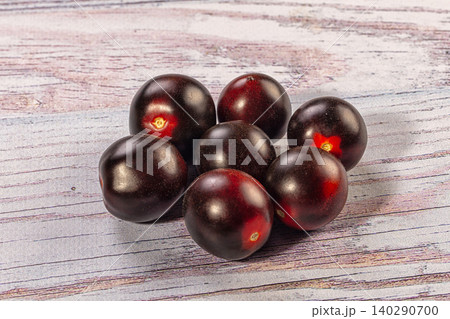 Black cherry tomatoes on rustic wooden surface 140290700