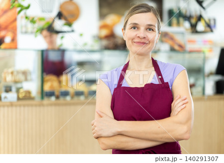 Polite waitress welcomes clients in cafeteria Polite waitress welcomes clients in cafeteria 140291307