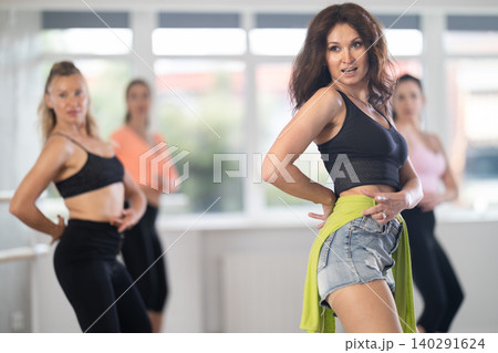 Confident woman leading group heels dance class in studio Confident woman leading group heels dance class in studio 140291624
