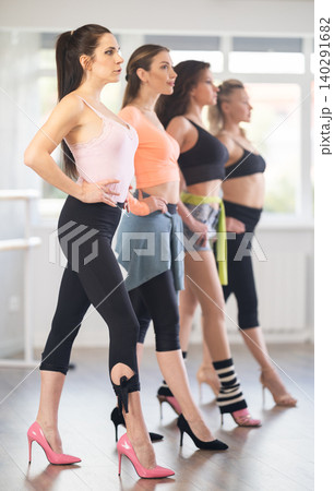 Female participants of project stand in row and perform dance in heels 140291682
