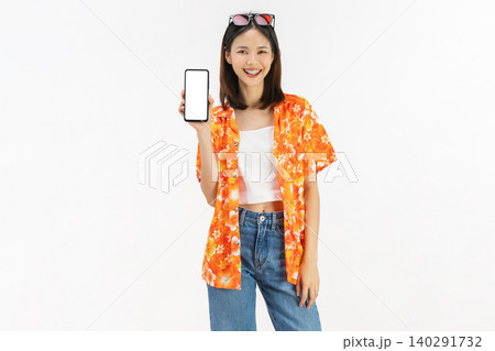 Portrait of young Asian woman in summer wearing floral shirt holding smartphone mockup of blank screen and smiling on white background 140291732
