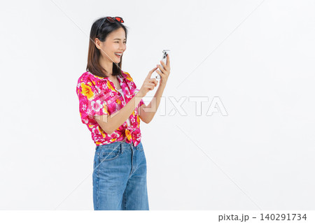 Portrait of young Asian woman in summer wearing floral shirt holding smartphone and smiling on white background. 140291734