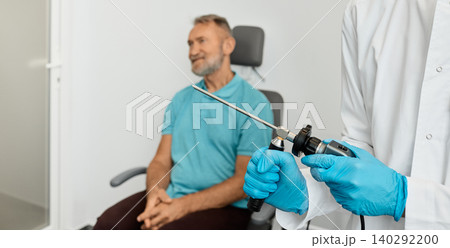 Ear endoscopy. ENT doctor examining senior man's ear using video endoscope at otolaryngology clinic Ear endoscopy. ENT doctor examining senior man's ear using video endoscope at otolaryngology clinic 140292200