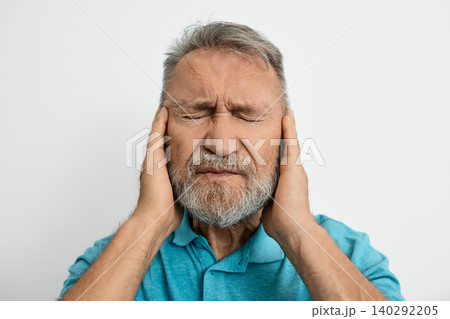 Elderly man feels discomfort in his ear, illustrating the challenges of hearing loss and ear problems he faces daily Elderly man feels discomfort in his ear, illustrating the challenges of hearing loss and ear problems he faces daily 140292205