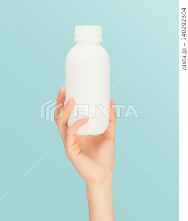 Hand holding medicine bottle on blue background, healthcare and treatment concept. Hand holding medicine bottle on blue background, healthcare and treatment concept. 140292304