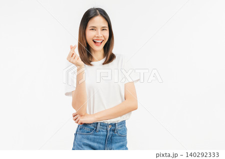 Happy young Asian woman making finger heart gesture and smiling isolated on white studio background. Happy young Asian woman making finger heart gesture and smiling isolated on white studio background. 140292333