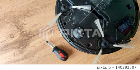 Robot vacuum cleaner with disassembled brush components and screwdriver on wooden surface, showcasing maintenance and repair process for home cleaning devices Robot vacuum cleaner with disassembled brush components and screwdriver on wooden surface, showcasing maintenance and repair process for home cleaning devices 140292507