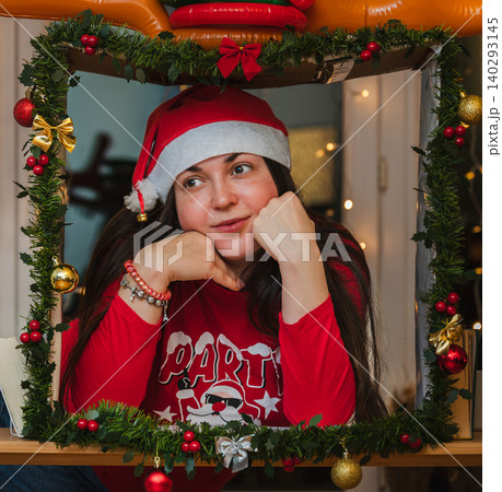 Woman in Santa Hat Resting Chin in Festive Frame 140293145