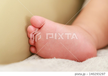 柔らかい布の上に置かれた赤ちゃんの小さな足のクローズアップ 140293297