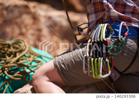 Person, harness and gear on mountain for rock climbing with safety equipment on waist in nature. Closeup of hiker or climber with rope, strap or cable hooks for trekking, fitness or extreme sports Person, harness and gear on mountain for rock climbing with safety equipment on waist in nature. Closeup of hiker or climber with rope, strap or cable hooks for trekking, fitness or extreme sports 140293306