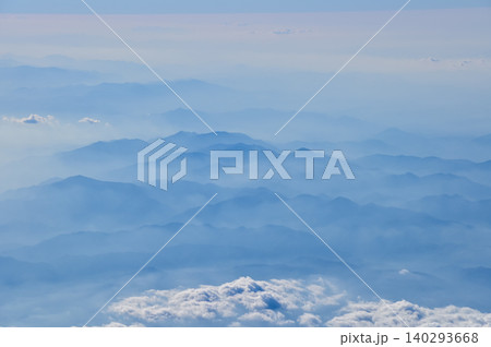 The view of the stunning landscape with mountains and clouds from the airplane window. Aerial view of the natural scene, mountain range. Travel and landscape scene. Travel and nature concept. The view of the stunning landscape with mountains and clouds from the airplane window. Aerial view of the natural scene, mountain range. Travel and landscape scene. Travel and nature concept. 140293668