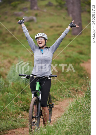 Cycling, fitness and woman success in nature for celebration, achievement and goals in training or journey. Excited person or winner with arms up for freedom, winning and yes on bicycle on mountains 140293712