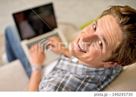 Man, portrait and laptop on sofa for online as freelance journalist for report research, connectivity or networking. Male person, above and internet for remote work in London, communication or web Man, portrait and laptop on sofa for online as freelance journalist for report research, connectivity or networking. Male person, above and internet for remote work in London, communication or web 140293730