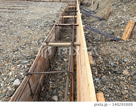 The steel reinforcement frame is carefully installed, preparing the foundation for pouring concrete. 140293889
