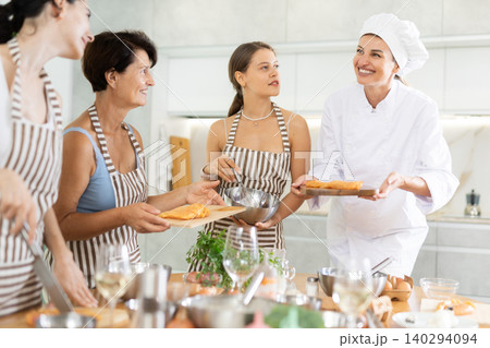 Young female cook holding cutting board with raw chicken 140294094