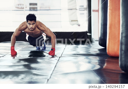 Athlete, portrait and push ups for sports in gym for training, wellness and workout for body. Man, exercise and gloves on hands, muscle and health for person in fitness centre, strong and serious Athlete, portrait and push ups for sports in gym for training, wellness and workout for body. Man, exercise and gloves on hands, muscle and health for person in fitness centre, strong and serious 140294157