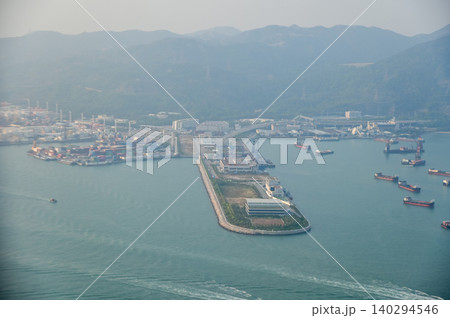Looking from the airplane window with Hong Kong cityscape. The view of Hong Kong city, Hong Kong landscape from the above. Landscape, travel concept and nature scene. Looking from the airplane window with Hong Kong cityscape. The view of Hong Kong city, Hong Kong landscape from the above. Landscape, travel concept and nature scene. 140294546